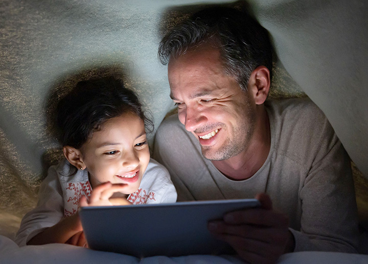 Man and daughter watching show or movie on a tablet